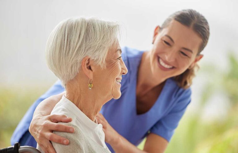 An older adult sitting at a kitchen table with unopened mail and a concerned family member nearby.